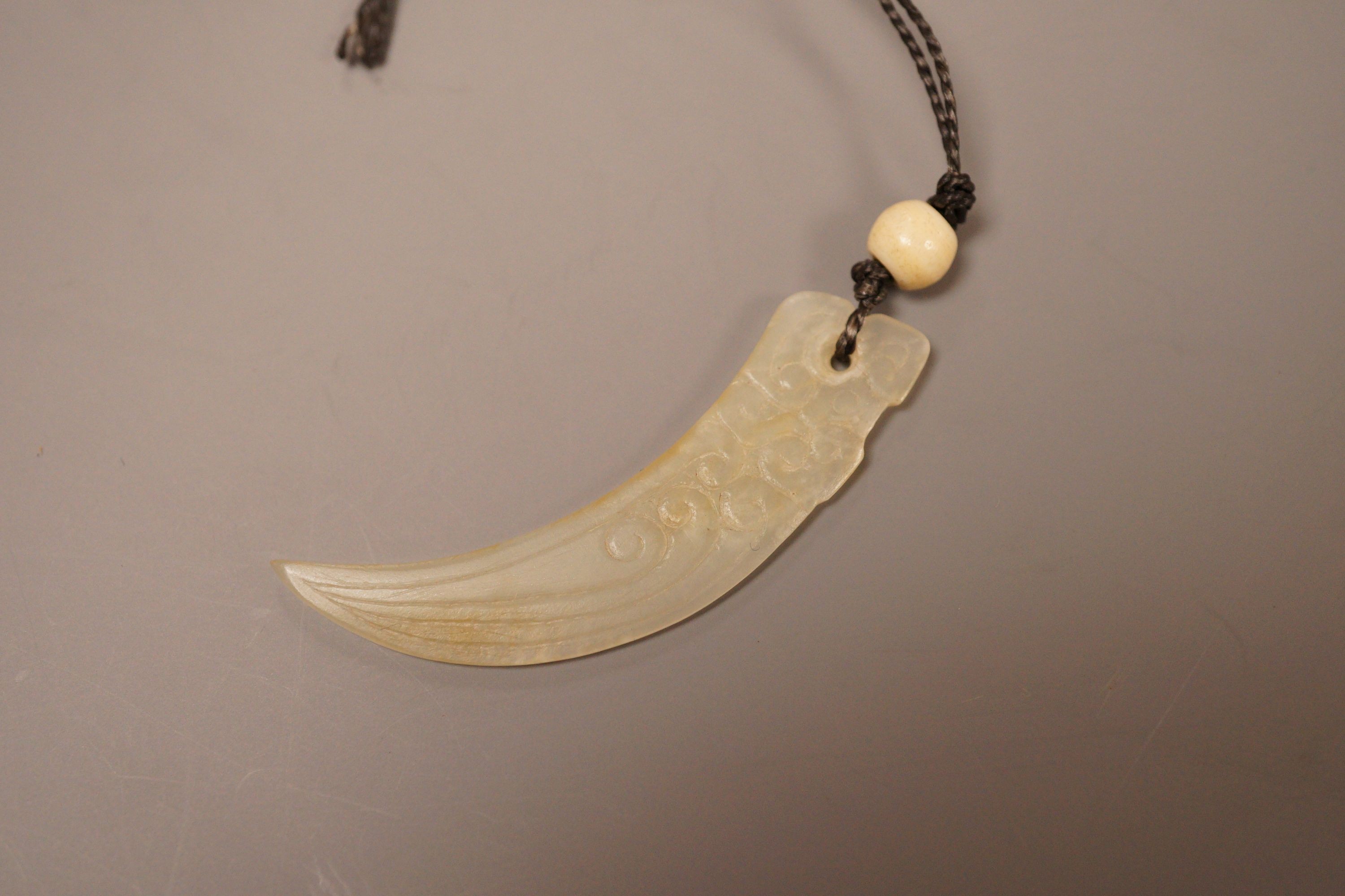 A Chinese jade tooth shaped pendant with bone bead
